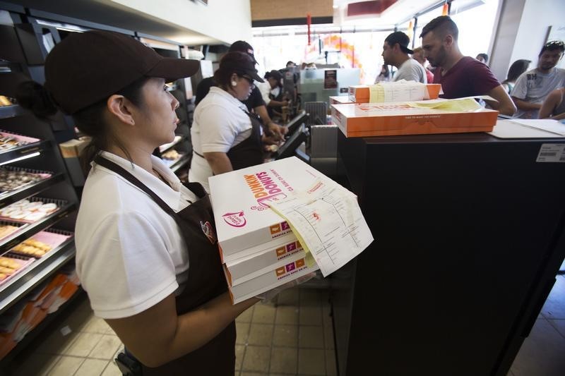 © Reuters. An employee holds boxes of donuts ready for pick up at a newly opened Dunkin' Donuts store in Santa Monica