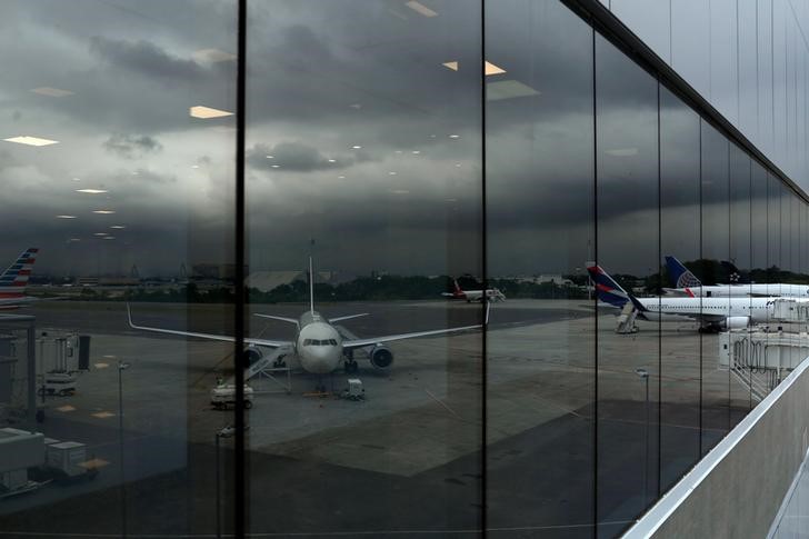 © Reuters. Airplanes are seen through a window at the new terminal at the international airport Galeao during its opening ceremony in Rio de Janeiro