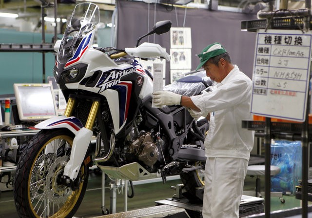 © Reuters. A worker is seen at an assembly line of Honda Motor Co.'s motorcycles at Honda's Kumamoto factory in Ozu town