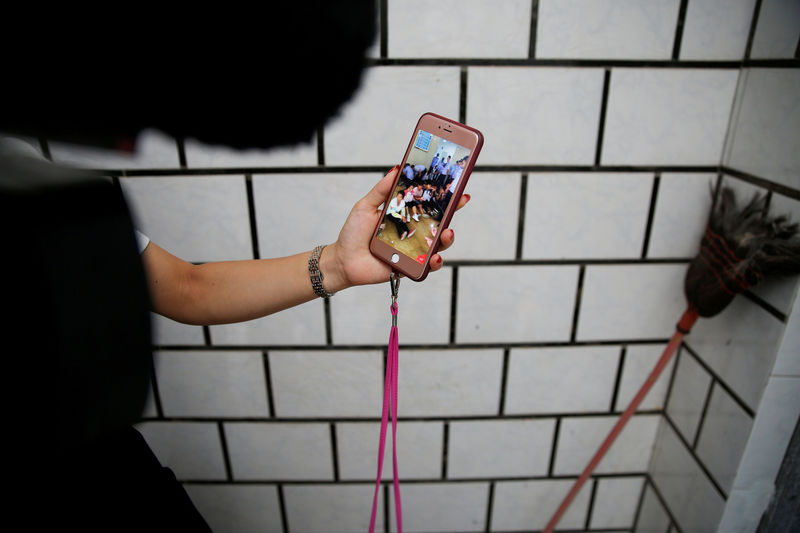 © Reuters. A woman displays footage on a mobile phone which she says shows residents detained by police in Wukan