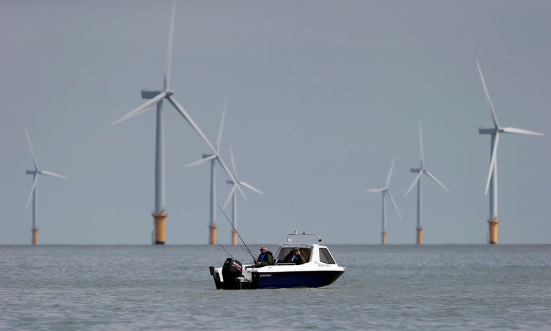 © Reuters. Two fishermen sit in their boat at the Gunfleet Sands Offshore Wind Farm near Clacton-on-Sea