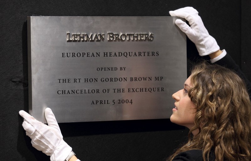 © Reuters. A Christie's employee poses for a photograph with the plaque from Lehman Brothers' European headquarters at Christie's in central London