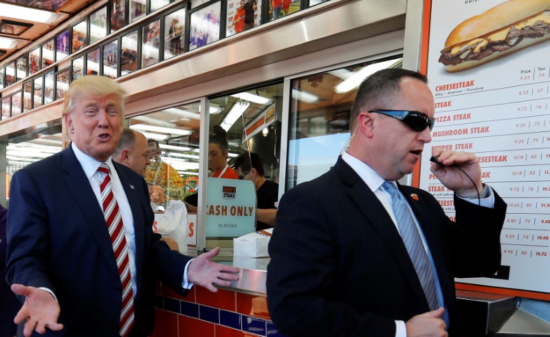 © Reuters. A Secret Service agent keeps watch as Republican presidential nominee Trump makes a stop at Geno's Steaks cheesesteak restaurant in Philadelphia