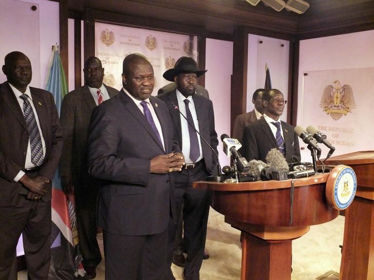 © Reuters. Sudan First Vice President Riek Machar (L), flanked by South Sudan President Salva Kiir (C) and other government officials, addresses a news conference at the Presidential State House in Juba