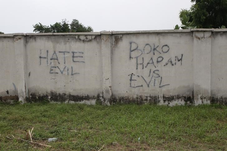 © Reuters. Writings describing Boko Haram are seen on the wall along a street in Bama