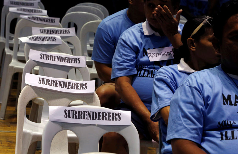 © Reuters. Residents involved with illegal drugs wait for fellow surrenderees before taking a pledge that they will not use or sell "Shabu" (Meth) again after surrendering to police and government officials in Makati