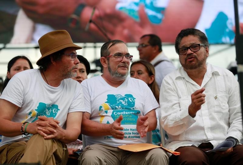 © Reuters. El líder de las FARC, Rodrigo Londoño, más conocido como "Timochenko",  (en el centro) habla con Pastor Álape (izquierda) e Iván Márquez (derecha), durante la ceremonia de clausura de un congreso rebelde cerca de El Diamante, en los Llanos