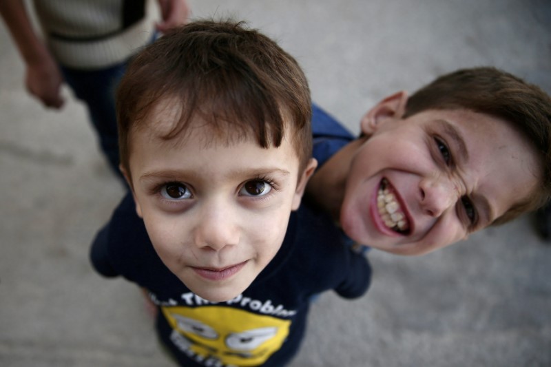 © Reuters. Boys pose while playing in the rebel-held Douma neighbourhood of Damascus