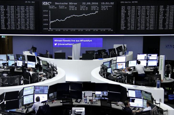 © Reuters. Traders work at their desks in front of the German share price index DAX board in Frankfurt