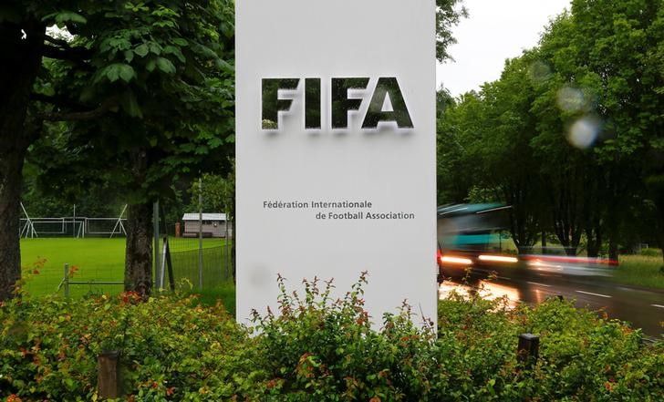 © Reuters. Cars drive past a logo in front of FIFA's headquarters in Zurich