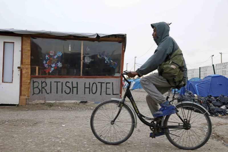 © Reuters. A migrant rides a bicycle in the northern area of the camp called the "Jungle" in Calais