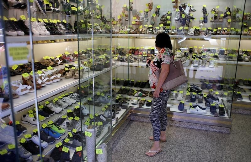 © Reuters. A woman stands in a shoes shop in Rome