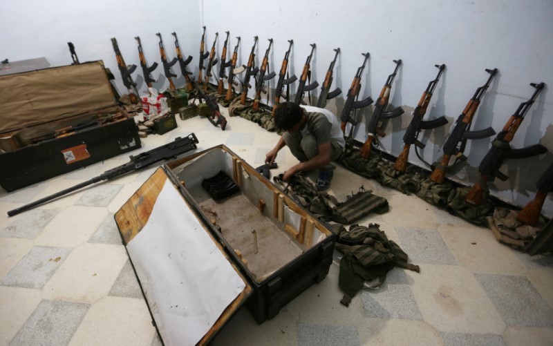 © Reuters. A rebel fighter of 'Al-Sultan Murad' brigade arranges weapons inside a warehouse in the northern Syrian rebel-controlled town of al-Rai, in Aleppo Governorate