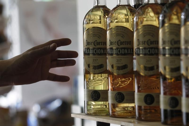 © Reuters. A man reaches for a bottle of Jose Cuervo Tequila in Mexico City