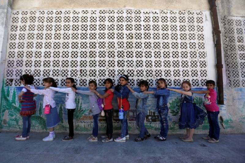 © Reuters. Girls stand in line on the first day of school in the rebel held town of Maaret al-Numan