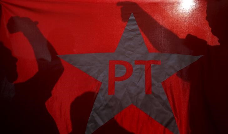 © Reuters. Manifestantes protestam atrás de bandeira do PT em São Paulo