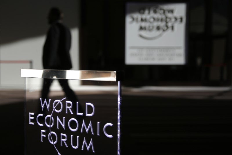 © Reuters. A man passes a logo during the annual meeting of the World Economic Forum (WEF) in Davos