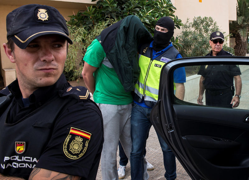 © Reuters. Spanish police officers lead a detained man during an operation in Melilla, southern Spain