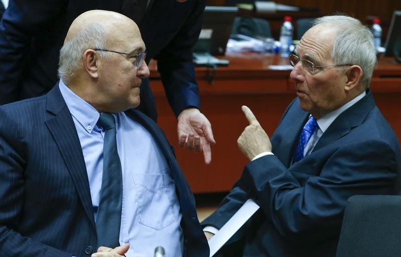© Reuters. French Finance Minister Sapin listens to German Finance Minister Schaeuble during a European Union finance ministers meeting in Brussels