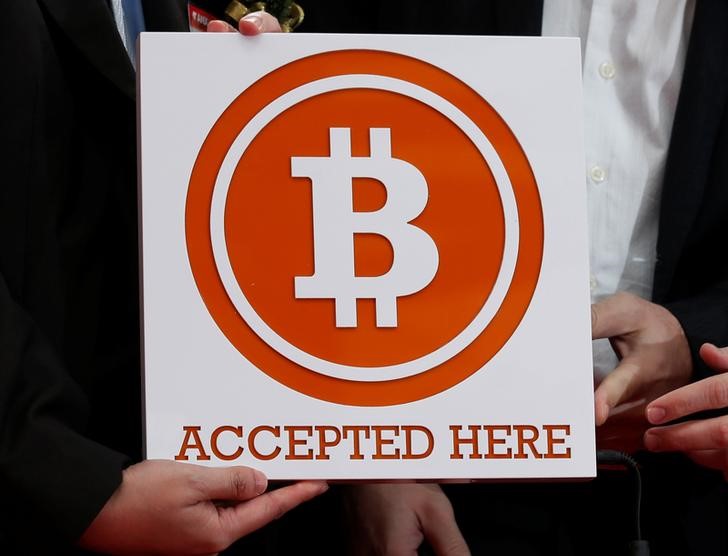 © Reuters. Bitcoin sign is held in Hong Kong
