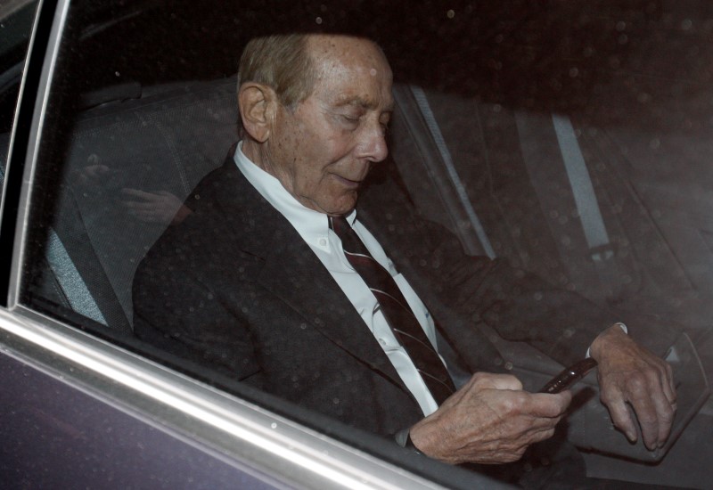 © Reuters. Former CEO of American International Group Inc, Greenberg, checks his phone inside a car after leaving a building in Downtown New York where he was deposed by the Attorney General's office