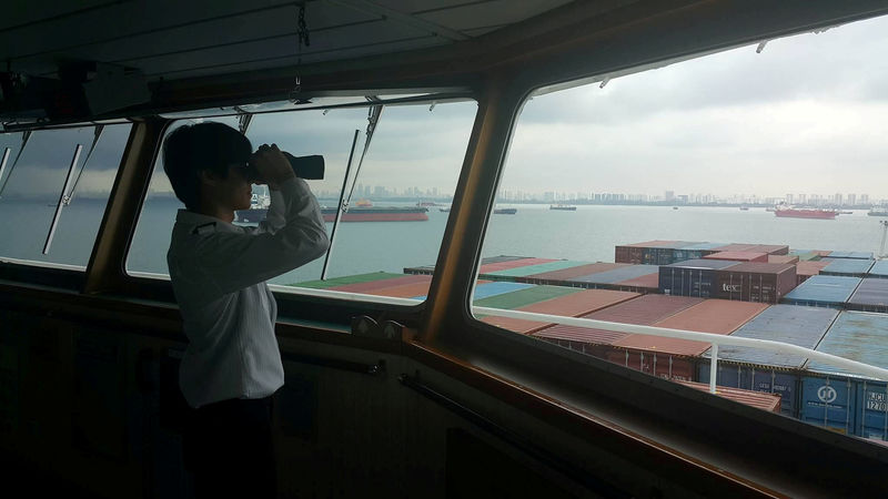 © Reuters. A crew member looks out from Hanjin Rome, stranded off the coast of Singapore, in this undated handout photo.