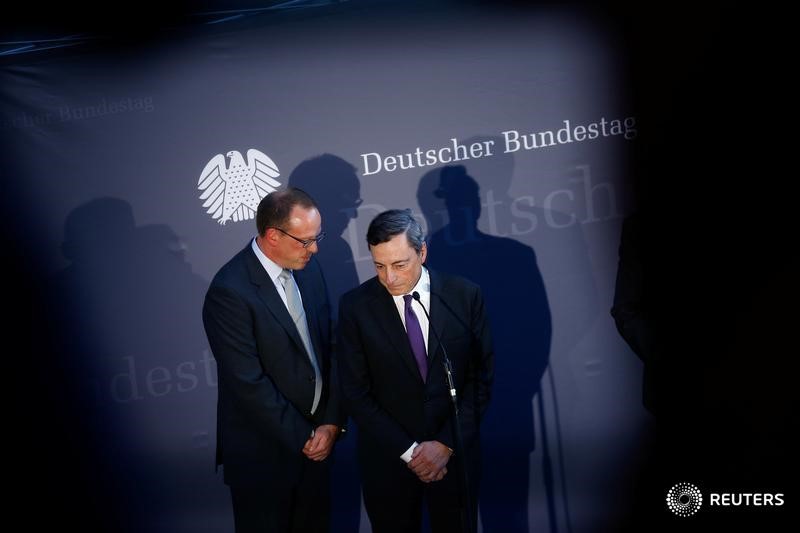 © Reuters. ECB President Draghi and an interpreter attend a news conference after a meeting with German lawmakers in Berlin