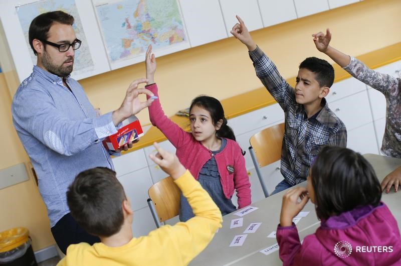 © Reuters. A teacher conducts a German lesson for children during a welcome class for immigrants from Syria, Poland and Romania at the Katharina-Heinroth primary school in Berlin