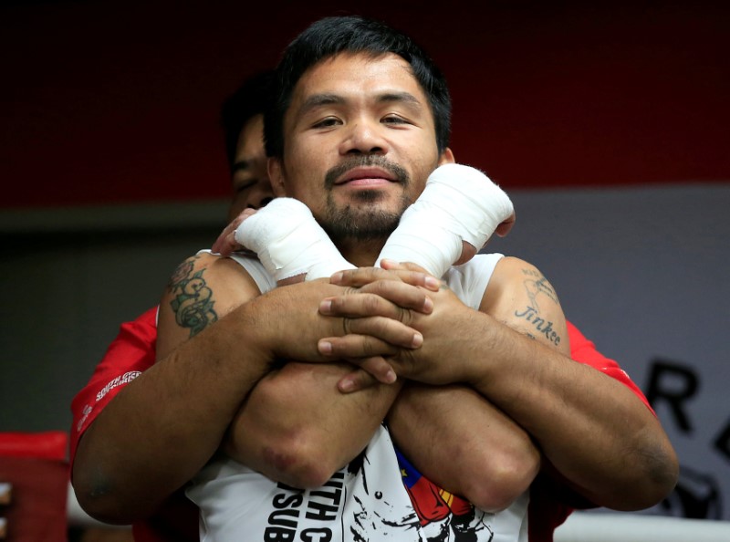 © Reuters. Senator and boxing champion Manny "Pacman" Pacquiao stretches during his training inside the Elorde gym in Pasay city, metro Manila