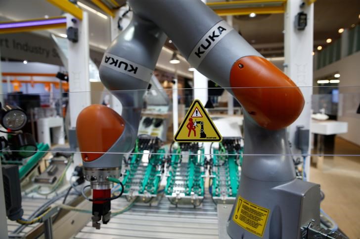 © Reuters. A sign alerts people to be cautious against a Kuka roboter arm at the Hannover Fair in Hanover