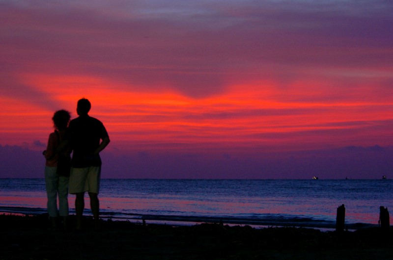© Reuters. Tourists enjoy the sunset at Kovalam beach