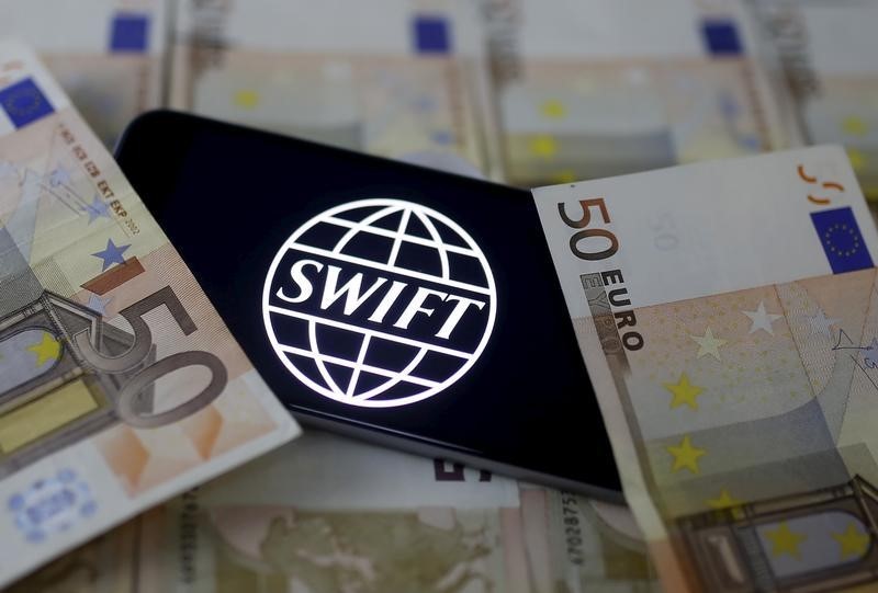 © Reuters. Swift code bank logo is displayed on an iPhone 6s on top of Euro banknotes in this picture illustration