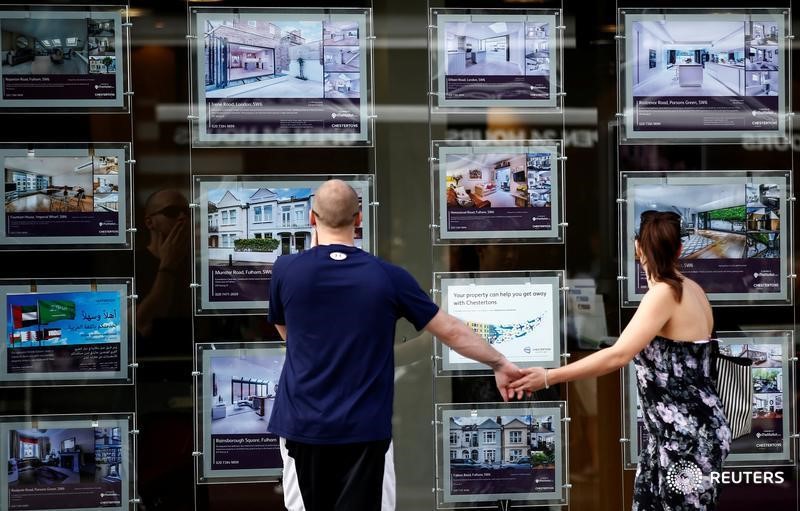 © Reuters. Люди изучают витрину офиса по продаже жилья в Лондоне