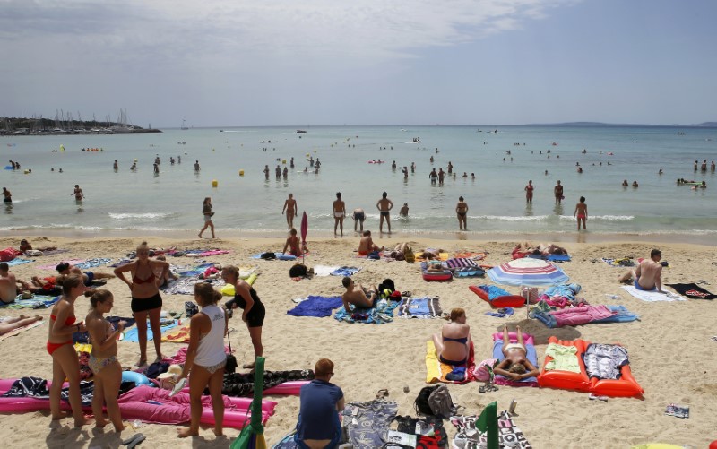 © Reuters. Tourists crowd Palma de Mallorca's Arenal beach on the Spanish Balearic island of Mallorca