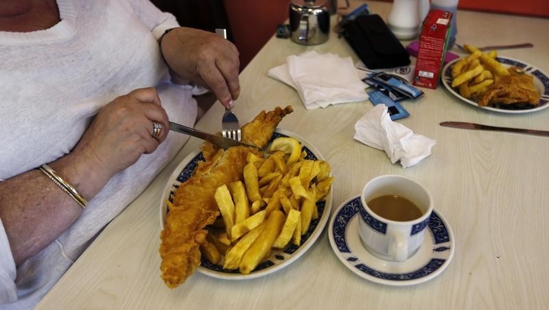 © Reuters. A woman eats fish and chips at Jack's Fish & Chips in west London