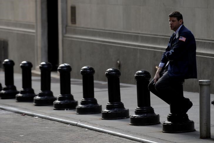 © Reuters. Трейдер отдыхает рядом с Нью-Йоркской фондовой биржей