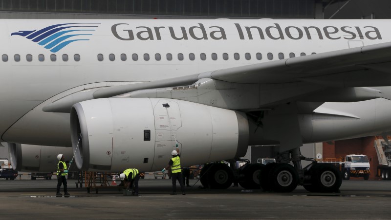 © Reuters. Workers clean the body of a Garuda Indonesia Airbus A320 aircraft inside Hangar 4 of PT Garuda Maintenance Facility Aero Asia at Soekarno-Hatta airport in Jakarta