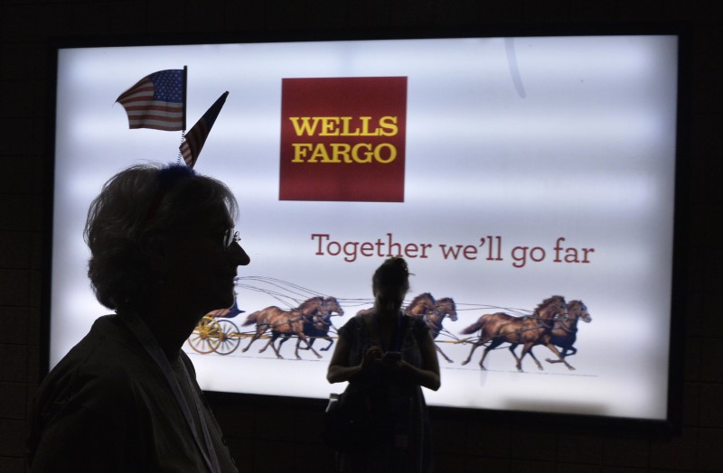 © Reuters. A woman wearing U.S. flags passes a sign at Wells Fargo Center at the Democratic National Convention in Philadelphia