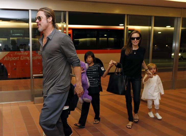 © Reuters. Brad Pitt e Angelina Jolie com filhos no aeroporto de Tóquio