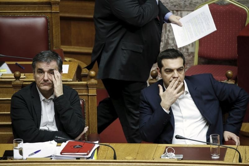 © Reuters. Greek PM Tsipras and Finance Minister Tsakalotos attend a parliamentary session before a budget vote in Athens