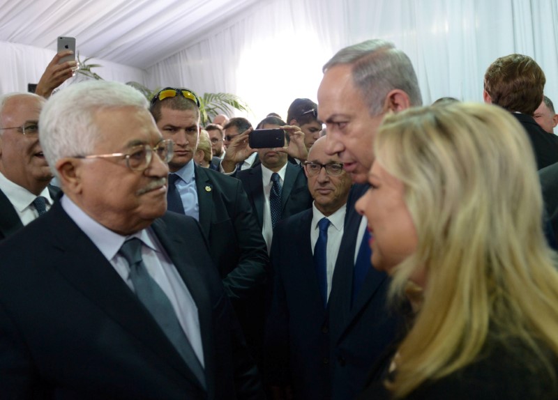 © Reuters. Premiê israelense, Benjamin Netanyahu, e sua mulher, Sara, conversam com presidente palestino, Mahmoud Abbas, durante funeral de Shimon Peres em Jerusalém