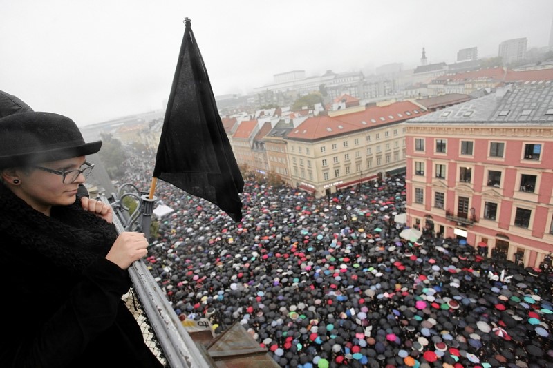 © Reuters. A woman observes thousands of people during an abortion rights campaigners' demonstration to protest against plans for a total ban on abortion in front of the Royal Castle in Warsaw