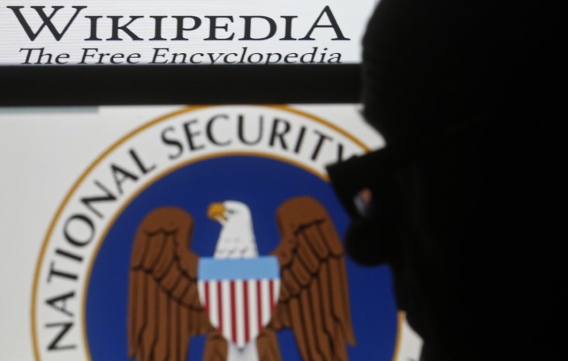 © Reuters. A man is silhouetted near logos of the U.S. National Security Agency (NSA) and Wikipedia in this photo illustration taken in Sarajevo