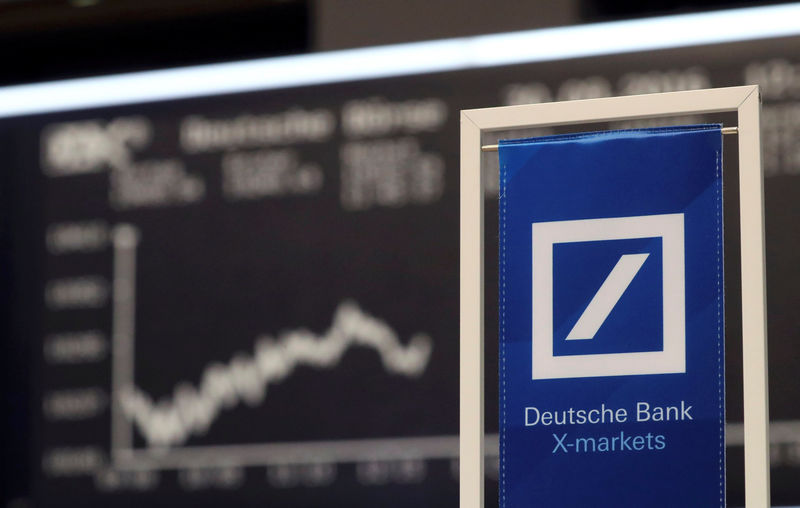 © Reuters. A banners of Deutsche Bank is pictured in front of the German share price index, DAX in Frankfurt
