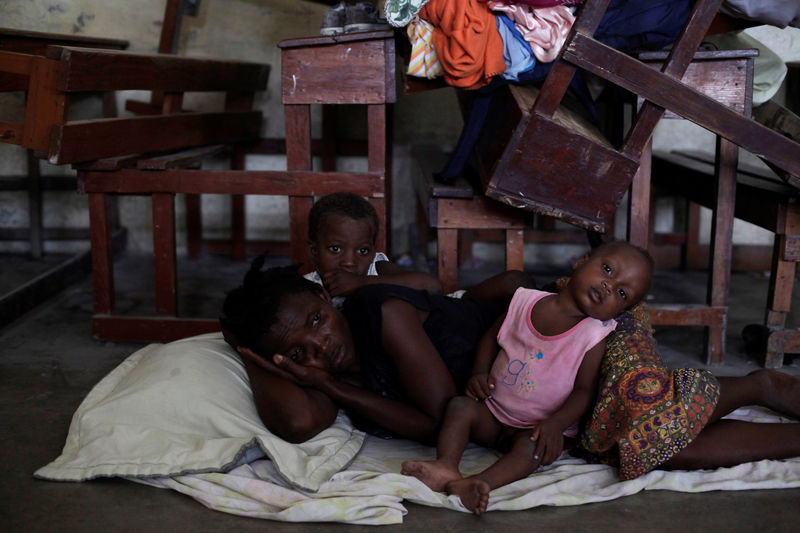 © Reuters. Mulher e filhos em abrigo após chegada do furacão Matthew em Les Cayes, Haiti