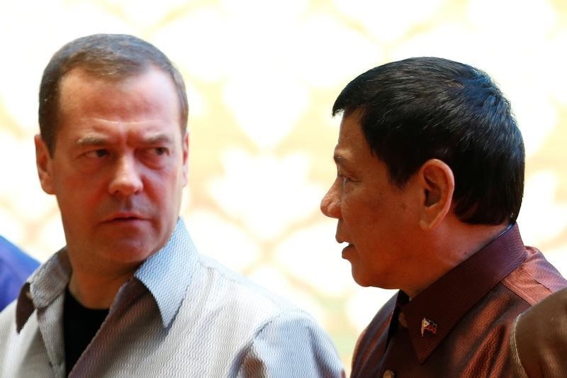 © Reuters. Philippine President Rodrigo Duterte chats with Russia's Prime Minister Dmitry Medvedev at the ASEAN Summit family photo in Vientiane