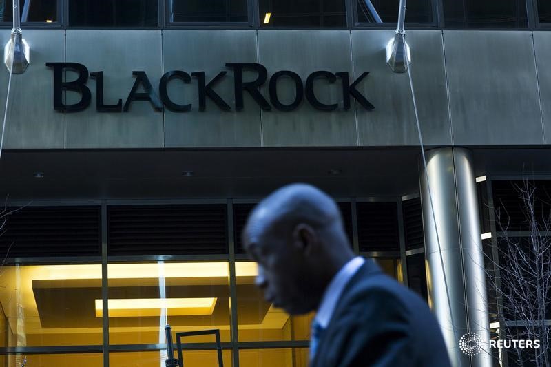 © Reuters. A man walks next to a BlackRock sign pictured in the Manhattan borough of New York