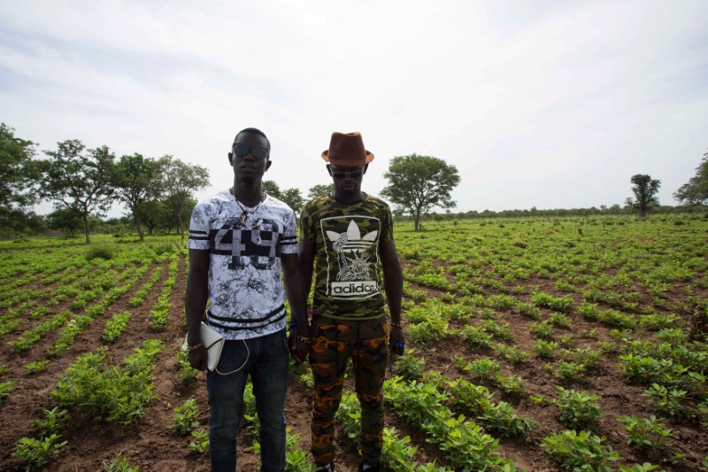 © Reuters. Local activists and would-be migrants Moussa Kebe and Ousmane Thiam pose for a photo on a farm in Goudiry