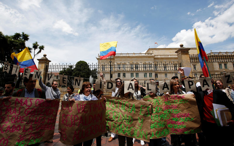 © Reuters. Supporters of the peace deal signed between the government and Revolutionary Armed Forces of Colombia (FARC) display Colombian flags during a rally in front  the Narino Palace, in Bogota