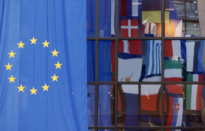 © Reuters. Flags are reflected in a window at the European Council building, a day before an E.U. heads of state summit in Brussels